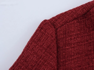 Close-up of wine red tweed fabric texture and shoulder stitching detail on this dress