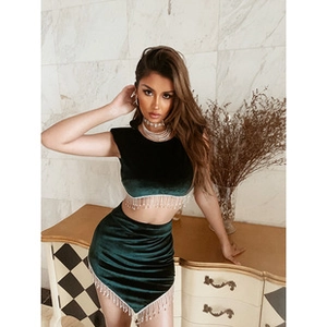 Close-up of velvet two-piece set with shimmering rhinestone fringe detail on top and skirt