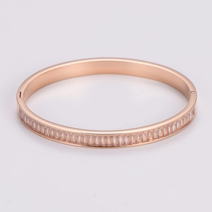 Detail of rose gold bangle with rectangular clear crystals in classic French setting
