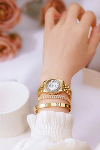 Close-up of gold quartz watch with mother of pearl dial and crystal bracelets on wrist