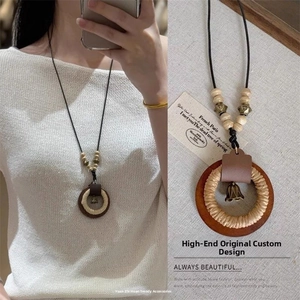 Dettaglio della collana lunga etnica vintage con anelli in legno ed elementi intrecciati