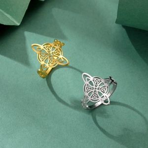 Vintage stainless steel Celtic knot rings in gold and silver set on dark green background