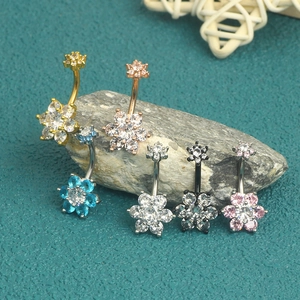 Macro shot of assorted flower-shaped cubic zirconia navel rings on a natural stone base