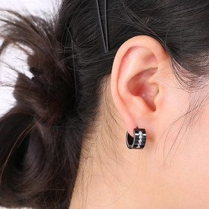 Close-up of black stainless steel hoop earring with white zircons on male model ear