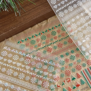 3D Christmas nail stickers with snowflake and reindeer patterns on rustic wood background