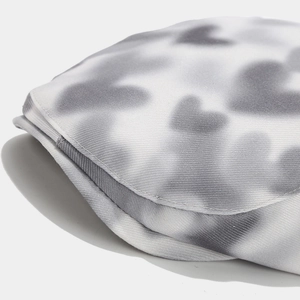 Détail du tissu en maille de béret avec motifs de cœur tie-dye et coutures raffinées