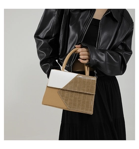 Fashionable patchwork crossbody bag with crocodile pattern and top handle worn by model