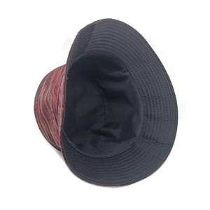 Detail of reversible bucket hat showing reddish-brown texture and black canvas lining