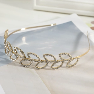 Close-up of golden leaf headband with sparkling rhinestones on a stylish magazine