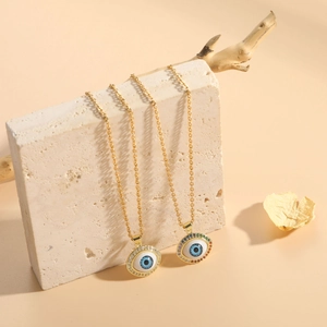 Detail of 14K gold plated evil eye necklaces with colorful zircon stones on stone