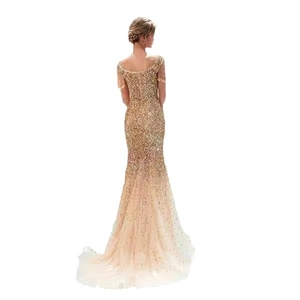 Abito da sera a sirena in paillettes dorate con maniche a frange e gonna in tulle trasparente