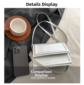 Detailed view of silver quilted crossbody bag with golden buckle on a textured fabric