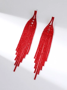 Detailed close-up of vibrant red rhinestone tassel earrings with a glossy metal finish