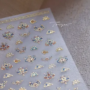 Detail view of Chinese style gold foil lotus and cloud patterns on nail art stickers
