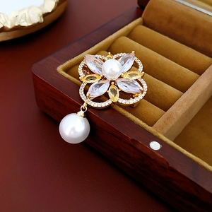 Detail of flower brooch with gold plating, white pearls, and crystals in a jewelry box
