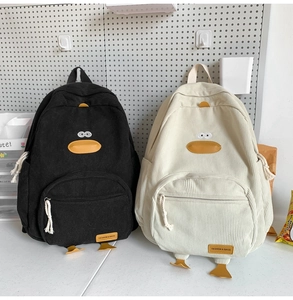 Detail of cute duck corduroy backpacks in black and cream featuring 3D legs and beak
