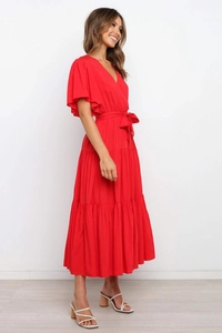 Detalle de vestido largo bohemio rojo con cuello en V, mangas de volantes y falda de capas