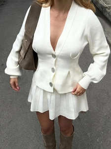 Detail view of the elegant white V-neck knitted cardigan with large silver buttons
