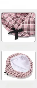 Detail view of pink plaid beret showing breathable lining and decorative black ribbon bow