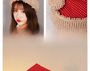 Close-up of red polka dot Christmas hat fabric with plush pom-poms and soft texture