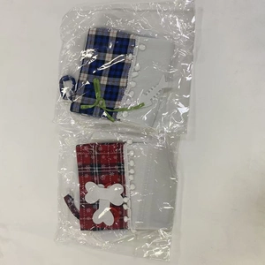 Detail view of plaid dog paw Christmas stockings in clear packaging on white background