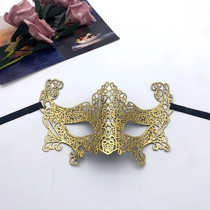 Detailed view of gold lace masquerade mask with intricate cutout patterns and black ties