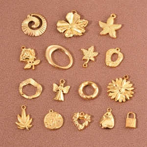 Set of 16 gold stainless steel pendants with flower leaf and star shapes on red fabric