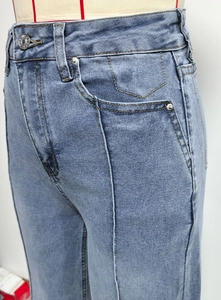 Detail van een lichtblauwe jeans met hoge taille, stiksels en knoopsluiting