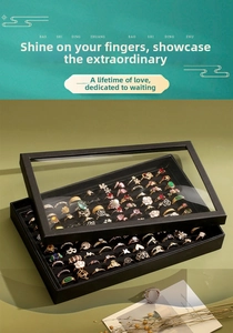 Close-up of 100-slot black ring organizer box with clear glass lid and velvet lining