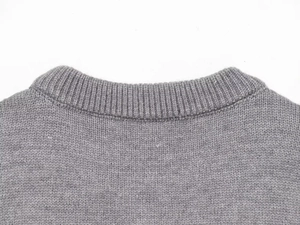 Close-up of the ribbed crewneck and soft wool-blend knit texture on a grey sweater