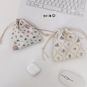 Floral drawstring pouches with bear and rabbit prints in a cozy desktop scene