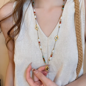 Detail of colorful beads with golden flower accents and a vintage-style inlaid pendant