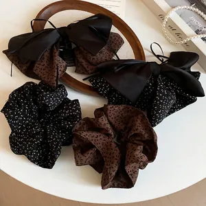 Chic 4-piece hair accessory set featuring leopard print bows and scrunchies on white desk