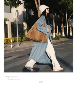 Close-up of a large brown pleated tote bag paired with a stylish blue wool coat