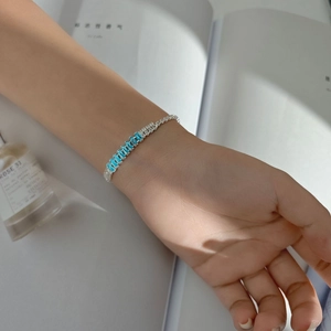 Detail of luxury silver bracelet with rectangular blue zircon stones and pavé diamonds