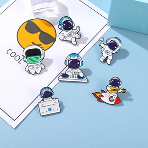 Detail of six enamel astronaut brooches featuring DJ and guitar themes on a blue background