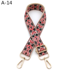 Close-up of ethnic style embroidered bag strap with floral patterns and gold metal buckles