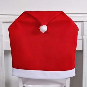Red Christmas hat chair cover with white trim and pom pom for festive dining decor