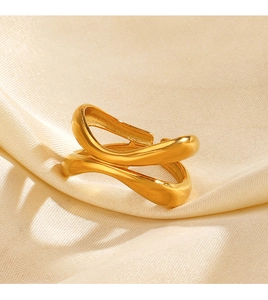 Dettaglio di un anello dorato irregolare su seta con una luce calda ed elegante