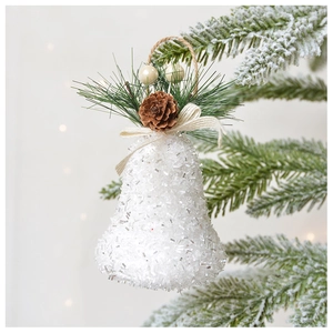 Cloche de Noël blanche scintillante avec pommes de pin suspendue à une branche enneigée