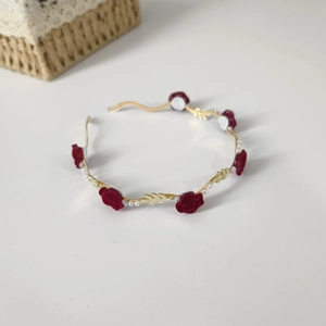 Golden headband with red roses and white pearls on a clean white background