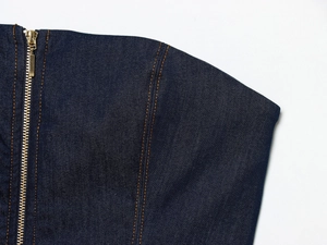 Vue détaillée du haut bustier en denim bleu avec fermeture éclair dorée et coutures orange