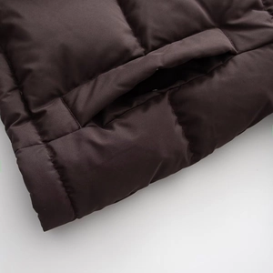 Detail of dark brown hooded jacket showing high-quality stitching and pocket seam