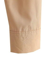 Détail du poignet d'une chemise kaki montrant la finition avec double couture renforcée