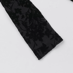Detail of black mesh fabric with elegant floral velvet flocking on the long sleeves