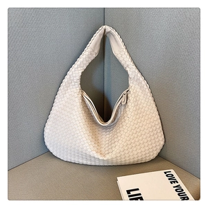 Detailed view of white hand-woven leather tote bag texture and large shoulder bag design