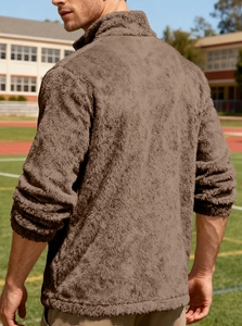 Outdoor shot showing texture of men's brown fleece jacket with high collar and warm fabric
