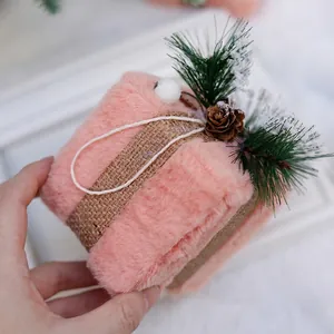 Pink plush Christmas gift box decoration with burlap ribbon, pine cones and snow pine needles