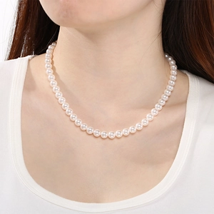 Gros plan d'un ensemble collier de perles blanches élégant porté par un mannequin