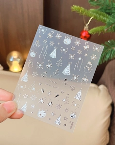 Close-up of silver Christmas nail stickers with snowflake, elk and snowman designs